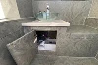 Modern bathroom vanity with open cabinet, glass sink, and marble-patterned surfaces in a 2021 Comitti Isola 33.