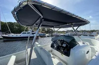 2021 Comitti Isola 33 boat with canopy, docked in a marina under clear skies.