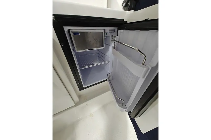 Got Fish Yacht Photos Pics Open refrigerator inside 2005 Tiara Yachts 3200 Open, showcasing interior storage space.
