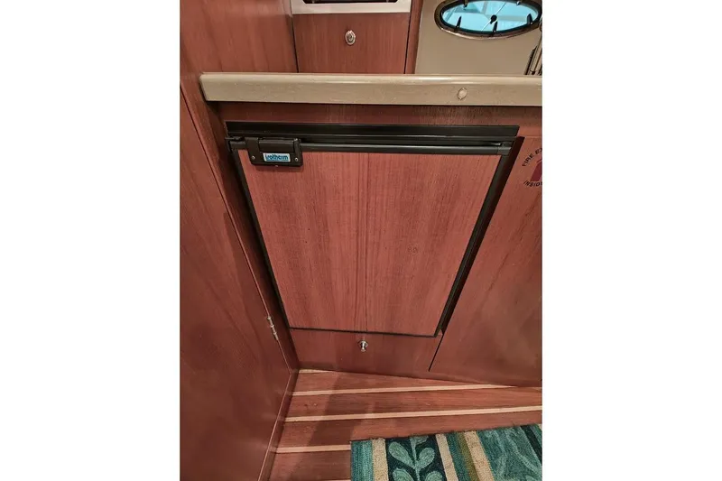 Got Fish Yacht Photos Pics 2005 Tiara Yachts 3200 Open interior with wooden cabinetry and compact fridge.