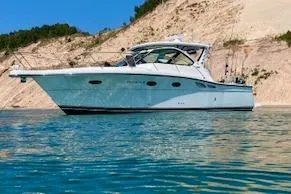 Got Fish Yacht Photos Pics 2005 Tiara Yachts 3200 Open on clear blue water near sandy cliffs.