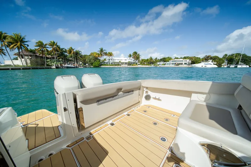  Yacht Photos Pics 2018 Boston Whaler 320 Vantage boat on serene water with palm trees and luxury homes.