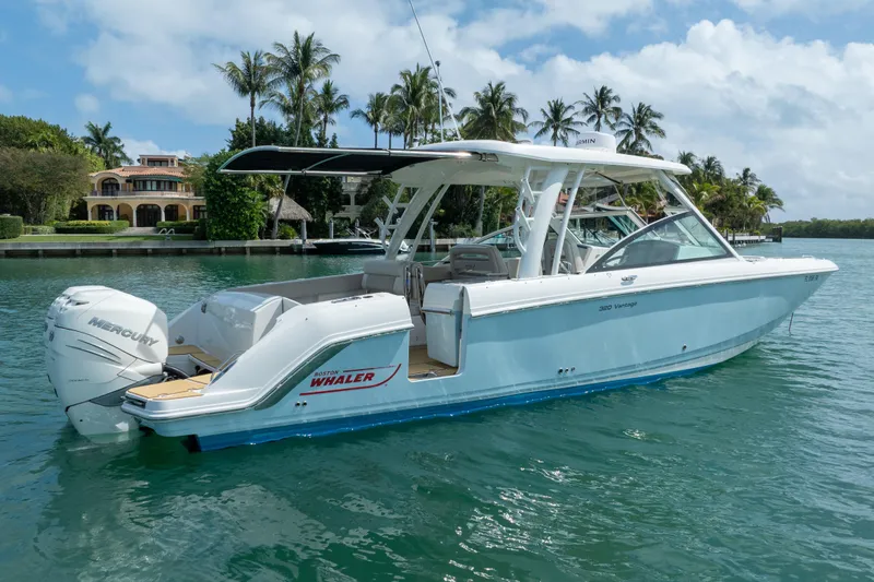  Yacht Photos Pics 2018 Boston Whaler 320 Vantage boat on water, surrounded by palm trees and luxury homes.