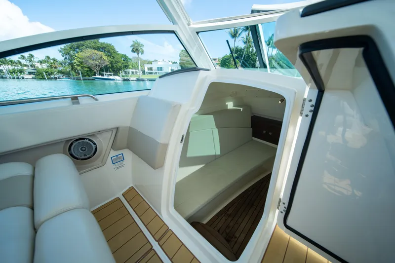  Yacht Photos Pics Interior view of 2018 Boston Whaler 320 Vantage boat cabin with seating and open door.