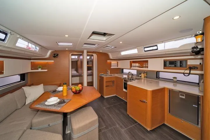 One Heart Yacht Photos Pics Luxurious interior of 2025 Dufour 44 yacht with modern kitchen and dining area.