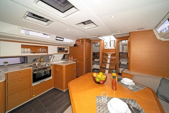 One Heart Yacht Photos Pics Luxurious interior of 2025 Dufour 44 yacht with modern kitchen and dining area.