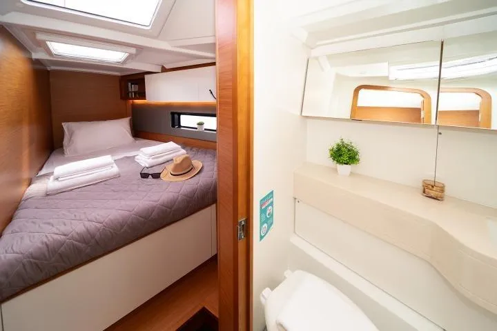 One Heart Yacht Photos Pics Luxurious cabin interior of 2025 Dufour 44 yacht with cozy bed and modern bathroom.