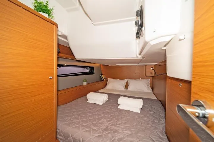 One Heart Yacht Photos Pics Cozy cabin interior of 2025 Dufour 44 yacht with double bed and wooden finish.