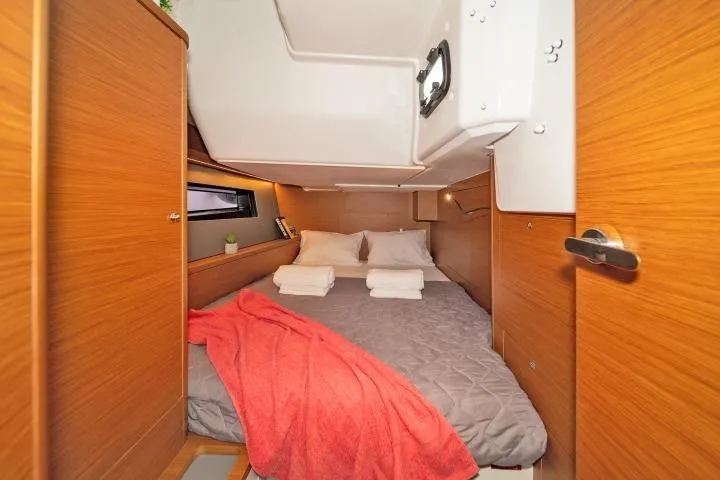 One Heart Yacht Photos Pics Luxurious cabin interior of 2025 Dufour 44 yacht with cozy bedding and wooden finish.