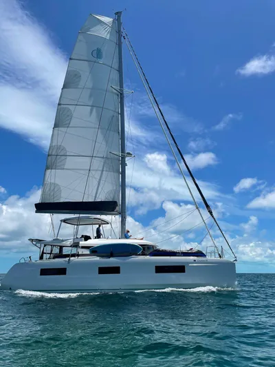 Clearlake III Yacht Photos Pics 2021 Lagoon 46 catamaran sailing on clear blue ocean under a bright sky.