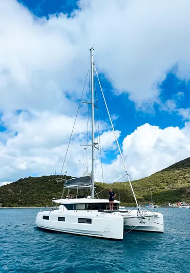 Clearlake III Yacht Photos Pics 2021 Lagoon 46 catamaran sailing in clear blue waters, with scenic hills in the background.