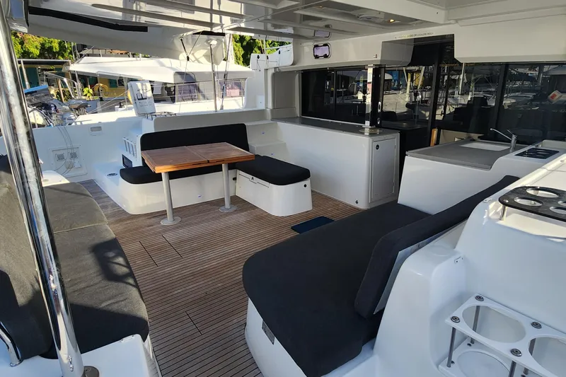 Clearlake III Yacht Photos Pics Spacious 2021 Lagoon 46 catamaran cockpit with seating, table, and modern amenities.