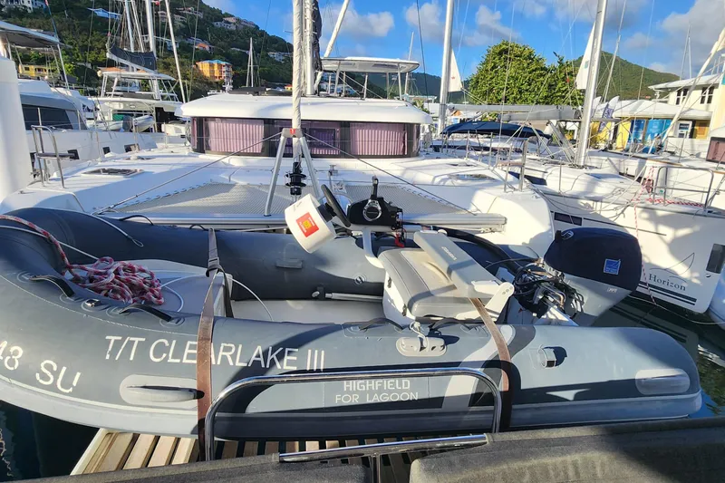 Clearlake III Yacht Photos Pics 2021 Lagoon 46 catamaran docked with inflatable dinghy, surrounded by other boats.