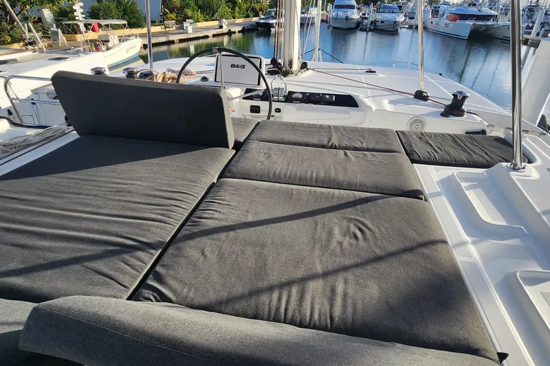 Clearlake III Yacht Photos Pics Luxurious 2021 Lagoon 46 catamaran with spacious sunbathing area, docked at marina.