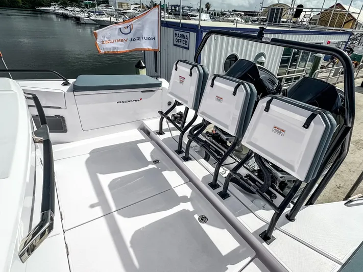  Yacht Photos Pics 2024 Axopar 37XC CROSS CABIN boat with seating and outboard motors at a marina.