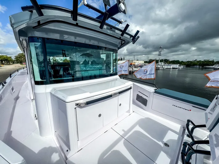  Yacht Photos Pics 2024 Axopar 37XC CROSS CABIN boat docked by the waterfront under cloudy skies.