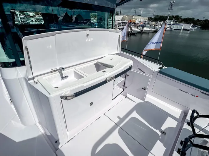  Yacht Photos Pics 2024 Axopar 37XC CROSS CABIN boat with outdoor sink and storage area.