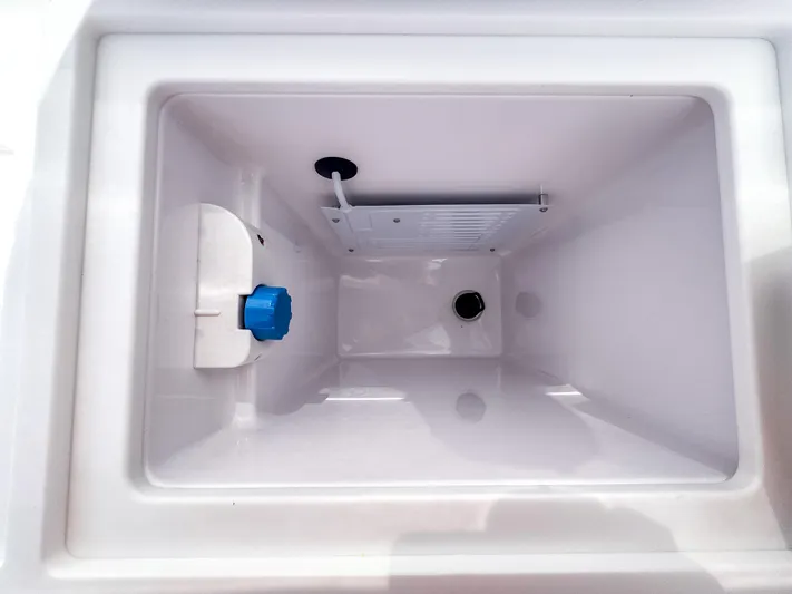  Yacht Photos Pics 2024 Axopar 37XC CROSS CABIN storage compartment with blue valve and drainage system.