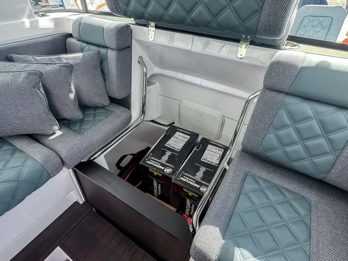  Yacht Photos Pics 2024 Axopar 37XC CROSS CABIN interior with storage compartment and cushioned seating.
