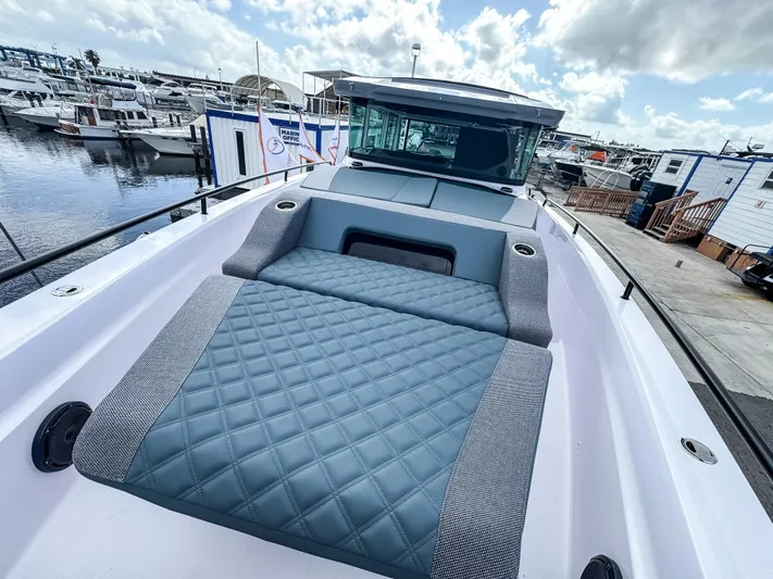  Yacht Photos Pics 2024 Axopar 37XC CROSS CABIN boat with spacious deck and luxurious seating at marina.