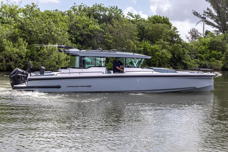  Yacht Photos Pics 2024 Axopar 37XC CROSS CABIN boat cruising on a calm river.