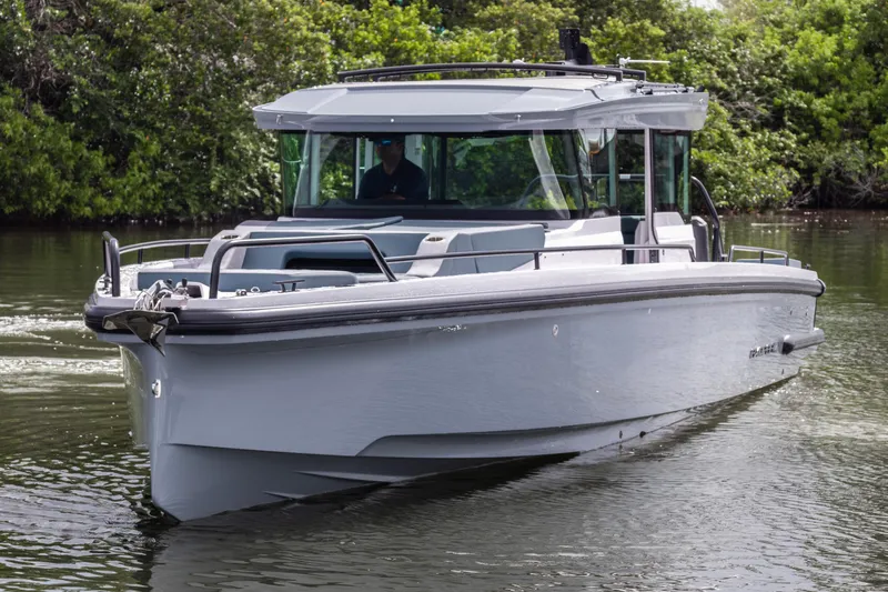  Yacht Photos Pics 2024 Axopar 37XC CROSS CABIN boat cruising on a calm waterway.
