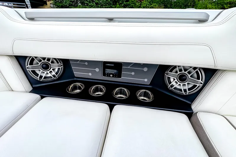  Yacht Photos Pics 2026 Ingenity EL boat interior with speakers and cup holders, featuring sleek white seating.