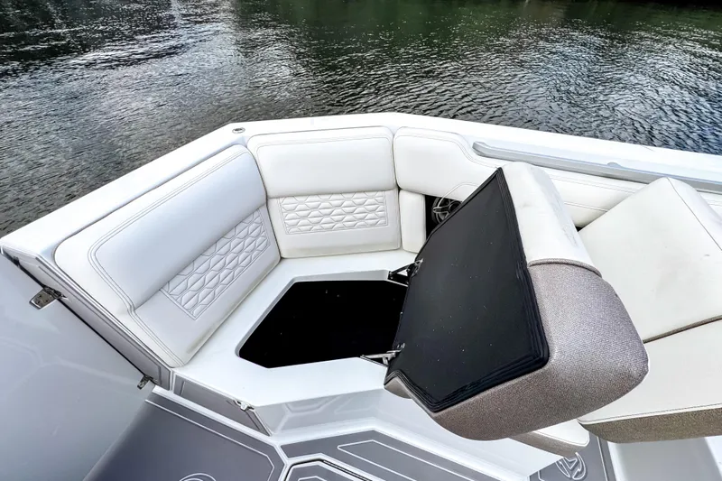  Yacht Photos Pics 2026 Ingenity EL boat interior with white cushioned seating and storage compartment.
