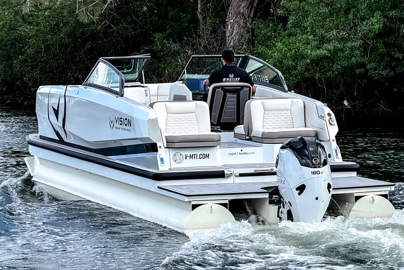  Yacht Photos Pics 2026 Ingenity EL electric boat cruising on a river, surrounded by lush greenery.