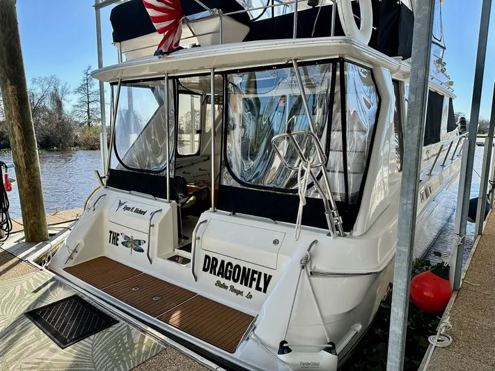 Dragonfly Yacht Photos Pics 1997 Sea Ray 550 Sedan Bridge yacht docked, featuring a spacious rear deck and clear enclosures.