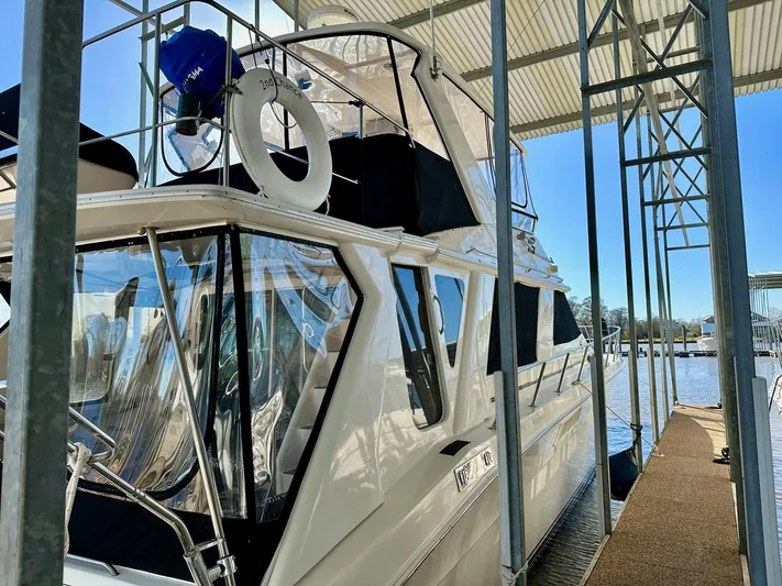 Dragonfly Yacht Photos Pics 1997 Sea Ray 550 Sedan Bridge yacht docked under a covered marina.