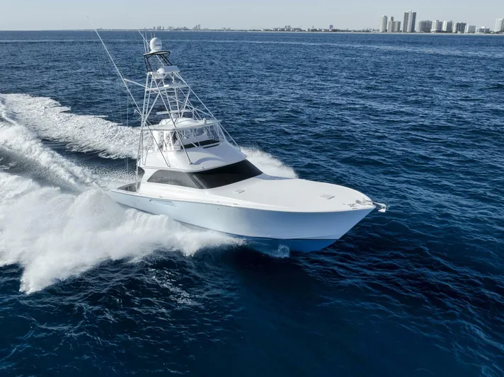 Big Fish II Yacht Photos Pics 2005 Viking Convertible yacht cruising on open ocean near city skyline.