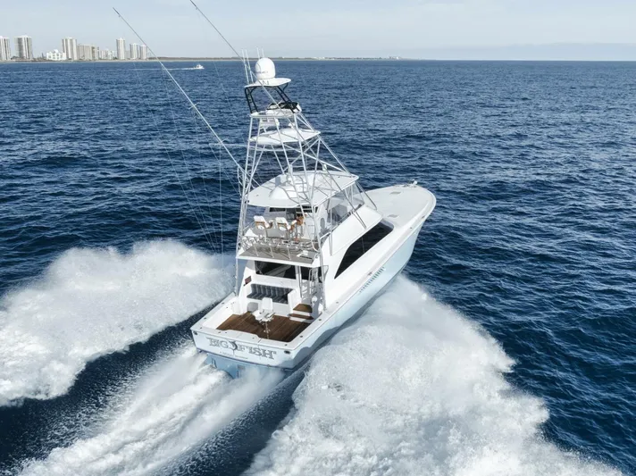 Big Fish II Yacht Photos Pics 2005 Viking Convertible yacht cruising on open sea with city skyline in background.