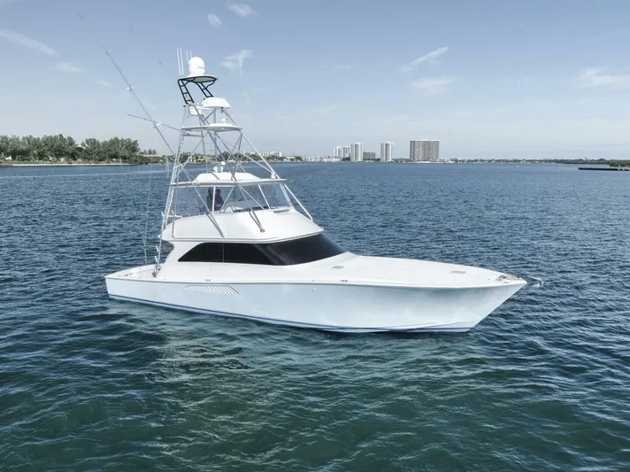 Big Fish II Yacht Photos Pics 2005 Viking Convertible yacht on calm blue water with city skyline in background.