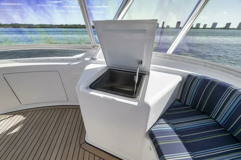 Big Fish II Yacht Photos Pics 2005 Viking Convertible yacht interior with open cooler and striped seating, overlooking water.