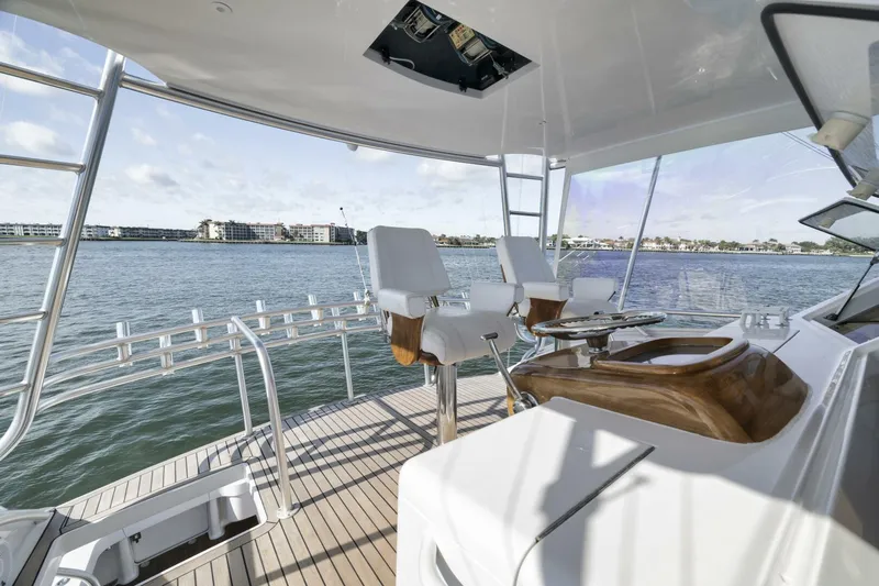 Big Fish II Yacht Photos Pics 2005 Viking Convertible yacht deck with seating, overlooking calm waters and distant shoreline.