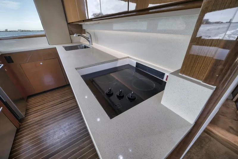Big Fish II Yacht Photos Pics Modern kitchen in a 2005 Viking Convertible yacht with sleek countertops and stovetop.