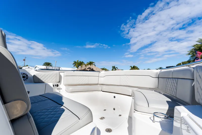  Yacht Photos Pics 2023 Pursuit S 328 Sport boat interior with luxurious seating under a clear blue sky.