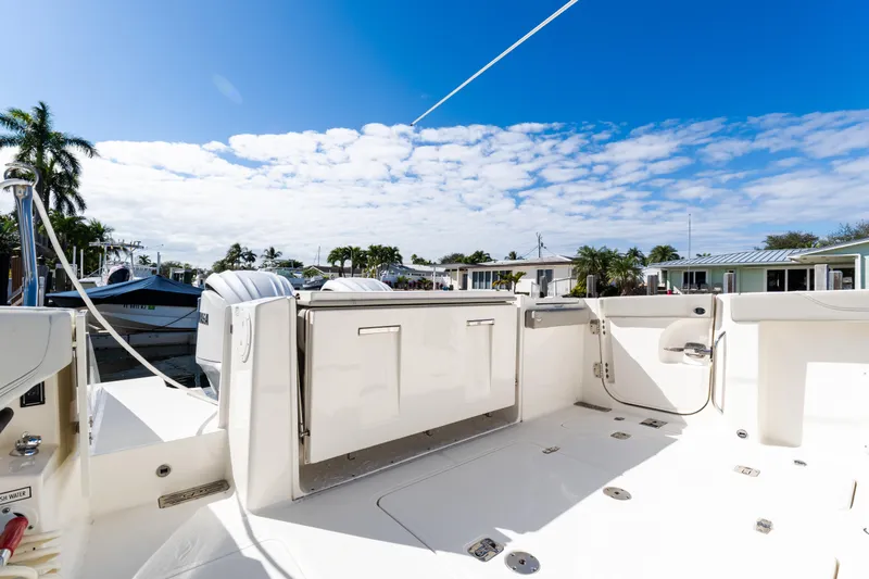  Yacht Photos Pics 2023 Pursuit S 328 Sport boat deck with clear sky and palm trees.