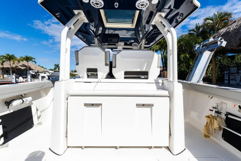  Yacht Photos Pics 2023 Pursuit S 328 Sport boat interior with seating and storage, under clear blue sky.