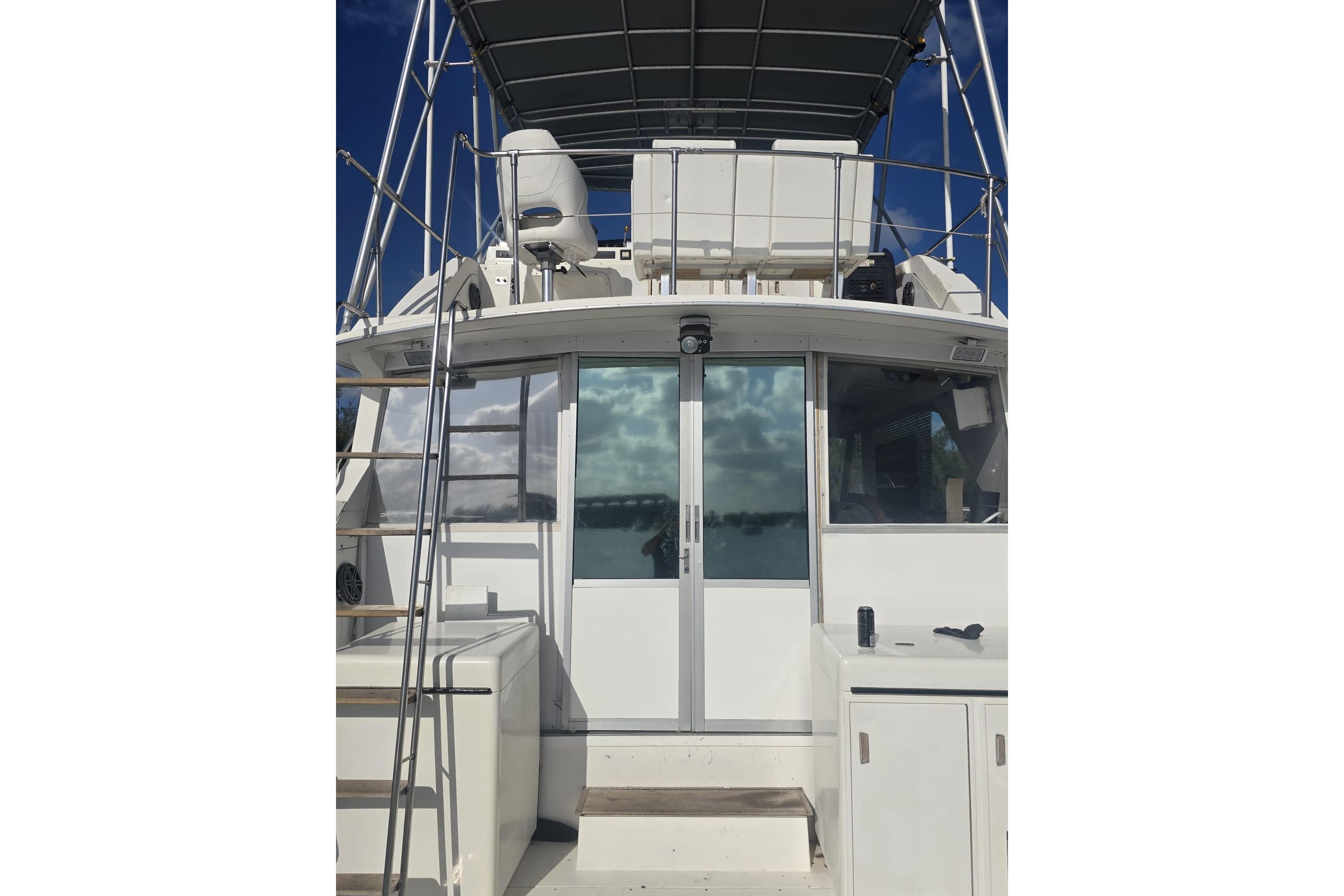 1977 Bertram 46 Convertible yacht with upper deck and sliding glass doors.