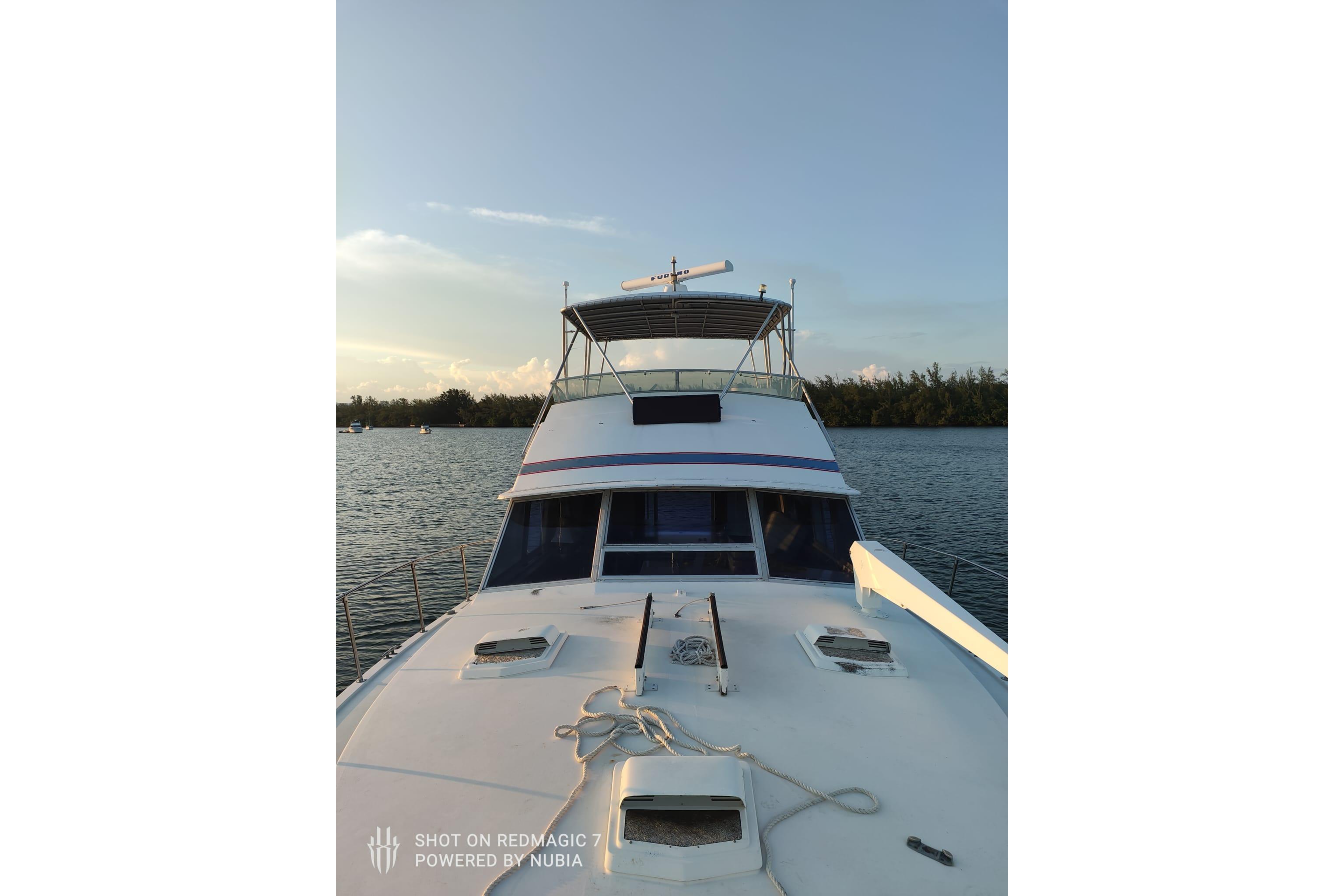 1977 Bertram 46 Convertible yacht on calm water at sunset.