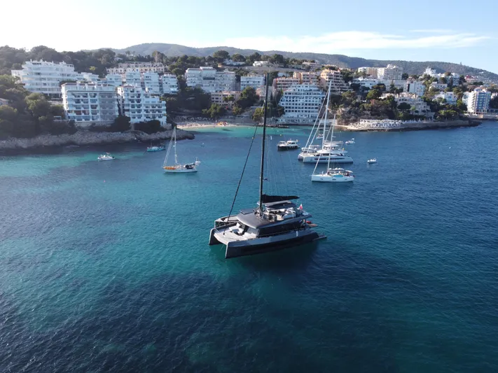Full Moon Yacht Photos Pics Aerial view of 2024 Moon 60 Sail yacht in a scenic coastal bay.