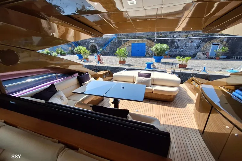 Candyman Yacht Photos Pics Luxurious 2009 Pershing 64 yacht interior with elegant seating and table, docked at a scenic port.