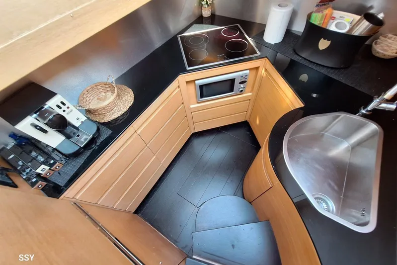 Candyman Yacht Photos Pics Compact kitchen in a 2009 Pershing 64 yacht with modern appliances and sleek design.