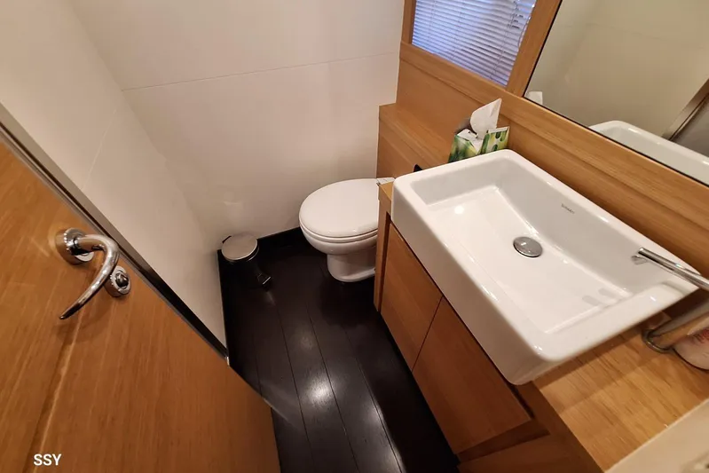 Candyman Yacht Photos Pics Bathroom interior of 2009 Pershing 64 yacht, featuring modern sink and wooden cabinetry.