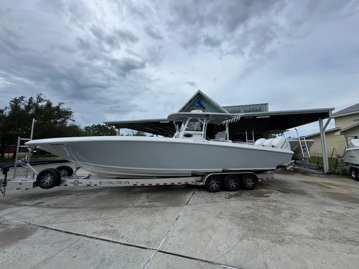  Yacht Photos Pics 2022 Fountain 38 CC boat on trailer under cloudy sky at a marina.