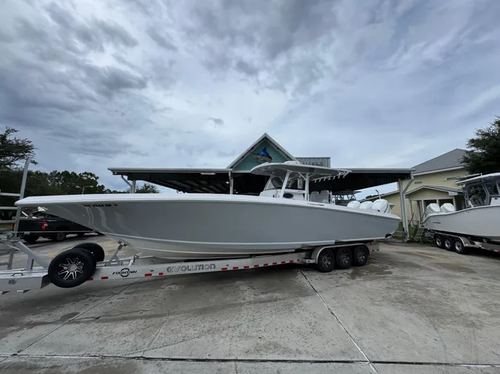  Yacht Photos Pics 2022 Fountain 38 CC boat on trailer, parked outdoors under cloudy sky.