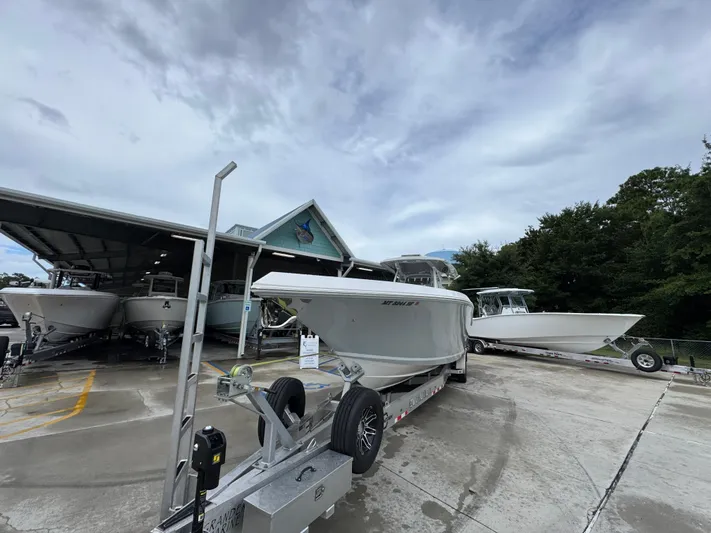  Yacht Photos Pics 2022 Fountain 38 CC boat on trailer at marina, cloudy sky background.