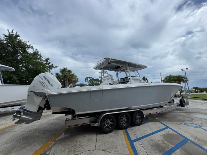 Yacht Photos Pics 2022 Fountain 38 CC boat on trailer, parked outdoors under cloudy sky.